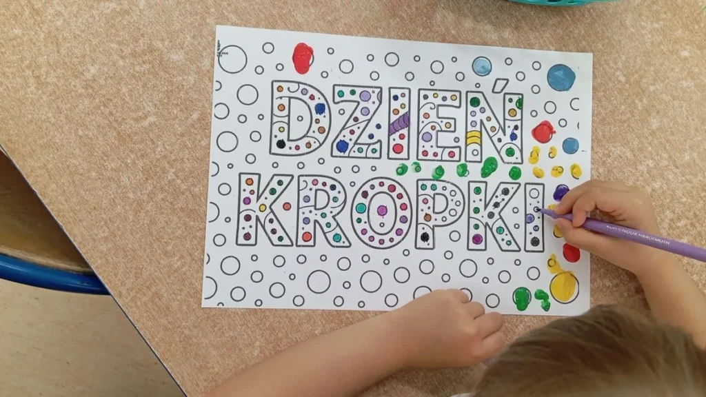 Kolorowe kropki i przybory plastyczne na stole