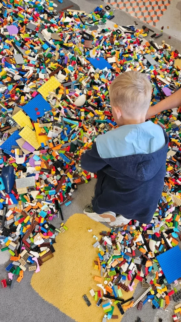 Uczestnik wybiera elementy z dużej puli klocków LEGO podczas warsztatów
