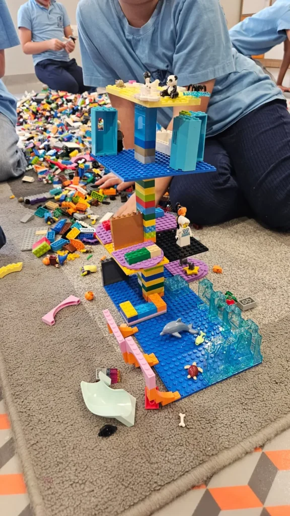 Wysoka, kolorowa konstrukcja z klocków wykonana podczas warsztatów LEGO